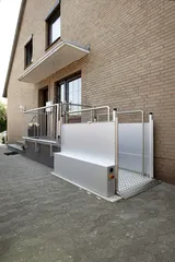 Hebebühne HBL 1000 vor dem Eingang eines Klinkerhauses, Plattform in unterer Position