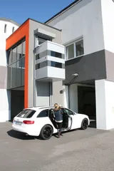 QuattroPorte-Außenaufzug an einem Firmengebäude, davor steigt eine Frau aus dem Auto
