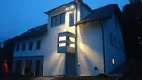 Wohnhaus mit angebautem QuattroPorte-Homelift am Abend, Kabine beleuchtet